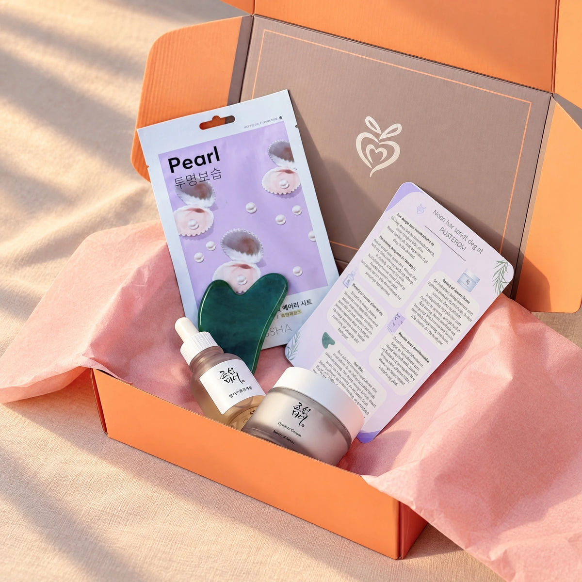 Åpen Avspent gaveeske med K-beauty fra Beauty of Joseon, ansiktsmaske og gua sha. Personlig hilsen og produktbeskrivelse følger med.
